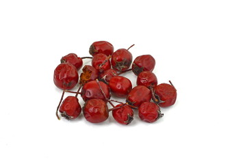 Dried medicinal herbs raw materials isolated on white. Fruit of Crataegus commonly called hawthorn, thornapple, May-tree, whitethorn, or hawberry. Cure for the heart.