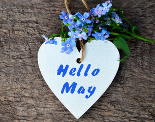 Hello May greeting card with decorative white heart and forget-me-not flowers on old wooden background.Springtime concept. © svf74