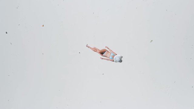 Aerial 4K view. Vertical motion flight over woman lying on tropical white sand beach at beautiful paradise island. Top view of relaxing girl