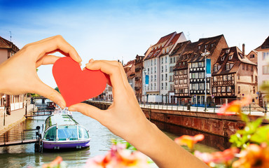 Hand hold red heart over Strasbourg and Ill river