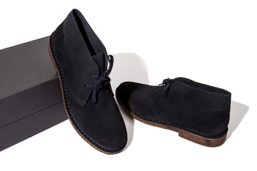 dark blue colored suede desert boots standing on black shoebox