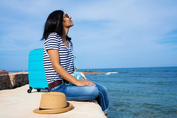 Fototapeta na wymiar Young indian woman sitting in front of the sea