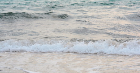 Beautiful soft waves of Blue Ocean with Sandy Beach Background close up. Sea sand wallpaper