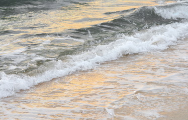 Beautiful soft waves of Blue Ocean with Sandy Beach Background close up. Sea sand wallpaper