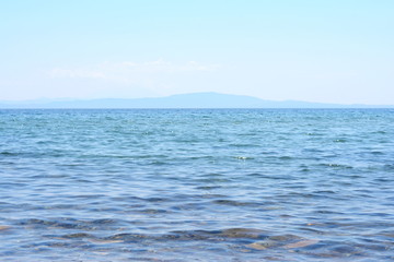 Obraz premium Beautiful soft waves of Blue Ocean with Sandy Beach Background close up. Sea sand wallpaper