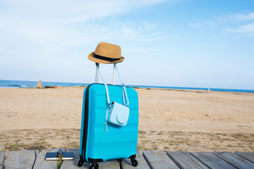 Close-up of blue luggage in front of the sea
