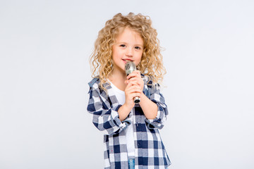 Obraz na płótnie Canvas baby girl with microphone smiling singing,Fat girl singing song into microphone. Young star, looking for talents