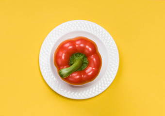 single red bell pepper  on yellow background