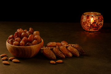 Dates in wooden bowl and lantern on stone table. Muslim holy month Ramadan Kareem. Copy space.