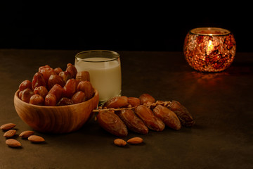 Dates in wooden bowl, milk and lantern on stone table. Muslim holy month Ramadan Kareem. Copy space.
