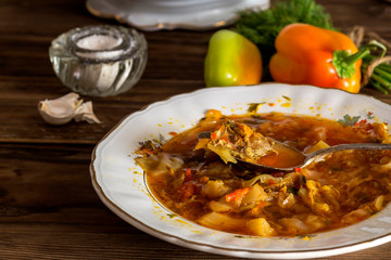 Plate of borsch on a wooden table (Ukrainian food)