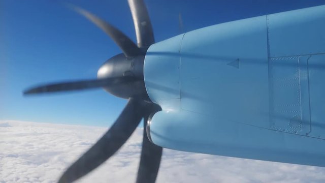 Airplane spinning propeller fly over white fluffy clouds and blue sky