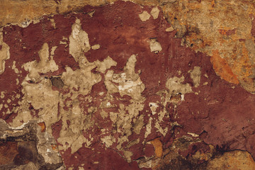 Old brown peeling wall. Abstract pattern on orange stucco backdrop. Texture of dirty dilapidated wall. Urban grunge texture background. Weathered plaster.