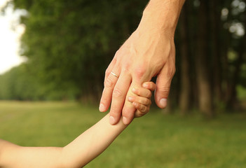  parent holds the hand of a small child
