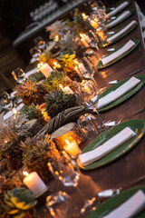 montaje de mesa para cena, platos servilletas y plaque con decoración orgánica e iluminación con velas
