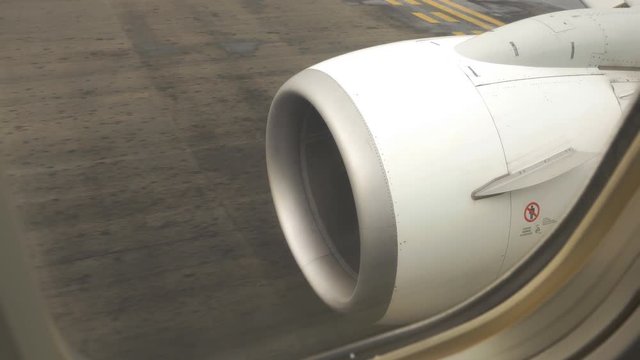 Commercial airliner taxiing on the tarmac. Detail of jet engine. View from inside the plane. Pearson International Airport, Toronto, Ontario, Canada.