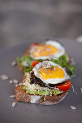 Desayuno con huevos estrellados sobre pan tostado integral con germen de trigo y semillas