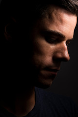 man side face looking down with a dark backgroung