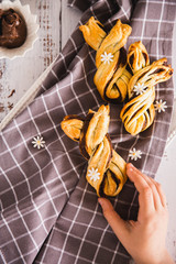 Kids hand taking delicious Palmiers with chocolate on wooden background