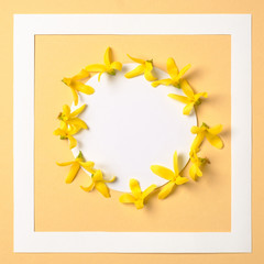 Creative layout made of yellow flowers plants look like bananas and rounded paper card note with frame, top view. Flat lay. Nature concept.