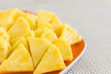 Chopped pineapple on a orange color plate