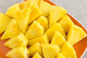 Chopped pineapple on a orange color plate