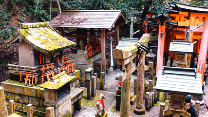Naklejka premium Orange gates and objects at Fushimi Inari-Taisha Shrine in Kyoto, Japan