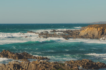 Waves crashing on the cliff and the rocks