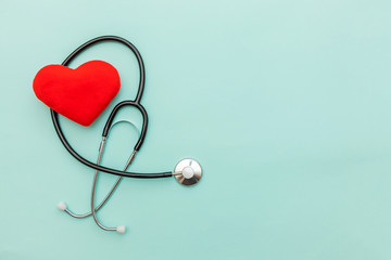 Simply minimal design with medicine equipment stethoscope or phonendoscope and red heart isolated on trendy pastel blue background. Instrument device for doctor. Health care life insurance concept