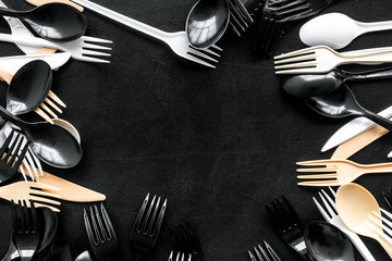 preparing food for restaurant with plastic flatware, spoons, forks, knifes frame on black background top view mockup