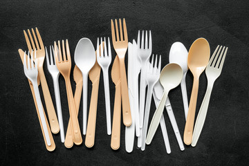 Plastic utilization and the Earth protection concept with flatware on black background top view