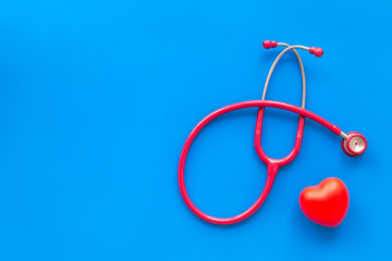 stethoscope and heart for diagnostic and cure of heart disease on blue background top view mockup