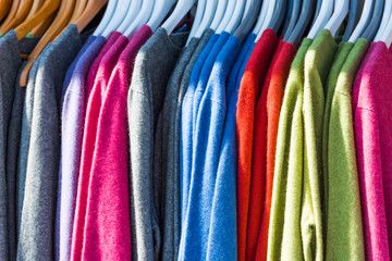 Pullovers hang on a hanger in the store, New Zealand. Close-up.