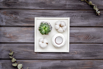 Work desk design with concrete decorations, candle and plant on wooden background top view