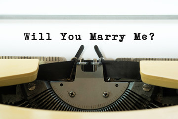 Will you marry me word on a yellow vintage typewriter. Valentines day concept. Marriage and wedding proposal.