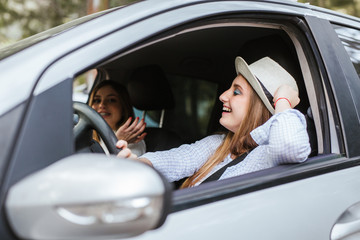 Two young girls have fun chatting inside the car
