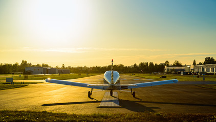 Small plane ready to take off at sunrise. - obrazy, fototapety, plakaty