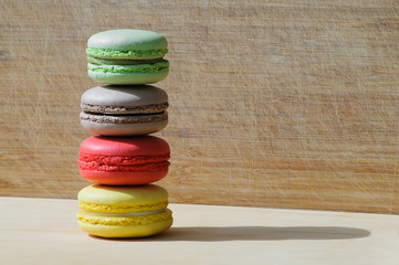Colorful tasty french macarons isolated on wood texture