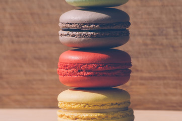 Colorful tasty french macarons isolated on wood texture