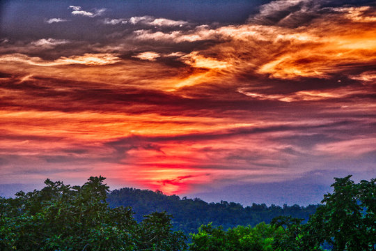 Dieses einzigartige Bild zeigt den sch&ouml;nen roten Sonnenuntergang mit gro&szlig;er Wolkenbildung hinter den Bergen in Hua Hin in Thailand