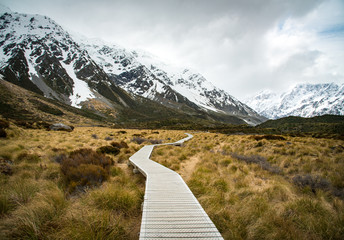 The wooden boardwalk in Hooker valley leading the path to Mount Cook (3,764 metres) the highest...