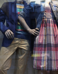Fototapeta na wymiar Fancy clothing on mannequins in window