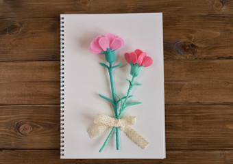 A sketchbook with flowers,carnations made of handmade used felt, on wooden background.(36-2）