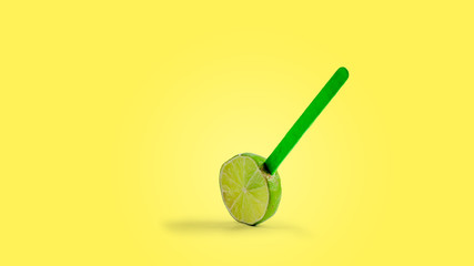 sliced lemon fruit on a stick. yellow background