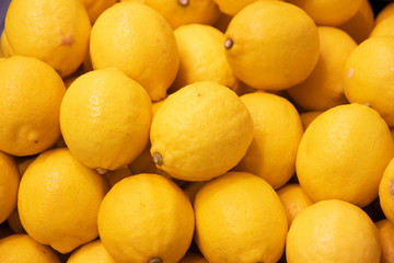 fresh lemons piled in market background