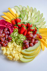 Fruit platter with fresh grapes, apple, pineapple, kiwi, mango, red ripe strawberry and pitaya. Colorful Fruit tray best health good food for party and holidays table.