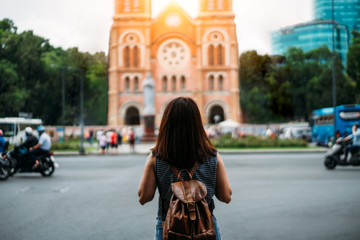 Young woman traveler traveling into Notre Dame Cathedral at Ho Chi Minh City in Vietnam