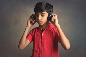 Indian young boy listen music with headphone