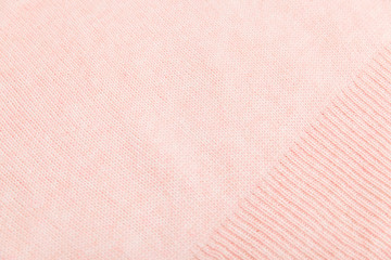 closeup of pink knitted fabric texture. facial loops. stockings with knitting needles and pink woolen thread