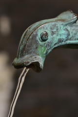 kupferrohr in form eines fischkopfes aus dem wasser fließt